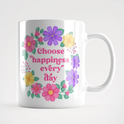 Motivational mug with quote: Choose happiness every day. Pink text with purple, pink and yellow floral wreath with green leaves and foliage.