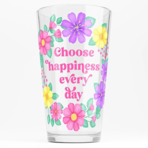 Motivational glass tumbler with quote: Choose happiness every day. Text with purple, pink and yellow floral wreath with green leaves and foliage.