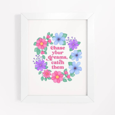 Motivational wall art with pink, blue and purple floral wreath on white background with text: Chase your dreams, catch them.