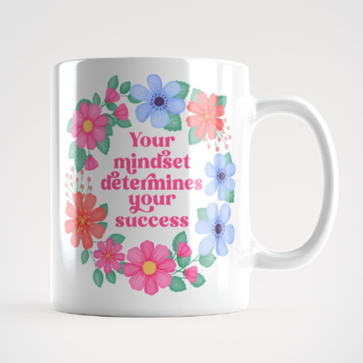 Motivational mug with quote: Your mindset determines your success. Pink text with blue, pink and orange floral wreath with green leaves and foliage.