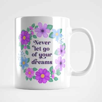 Motivational mug with quote: Never let go of your dreams. Text with purple, violet and blue floral wreath with green leaves and foliage.