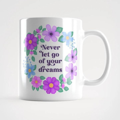 Motivational mug with quote: Never let go of your dreams. Text with blue and violet floral wreath with green leaves and foliage.