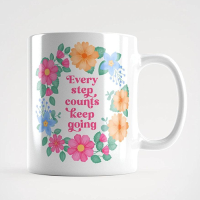 Motivational mug with quote: Every step counts keep going. Pink text with blue, pink and orange floral wreath with green leaves and foliage.